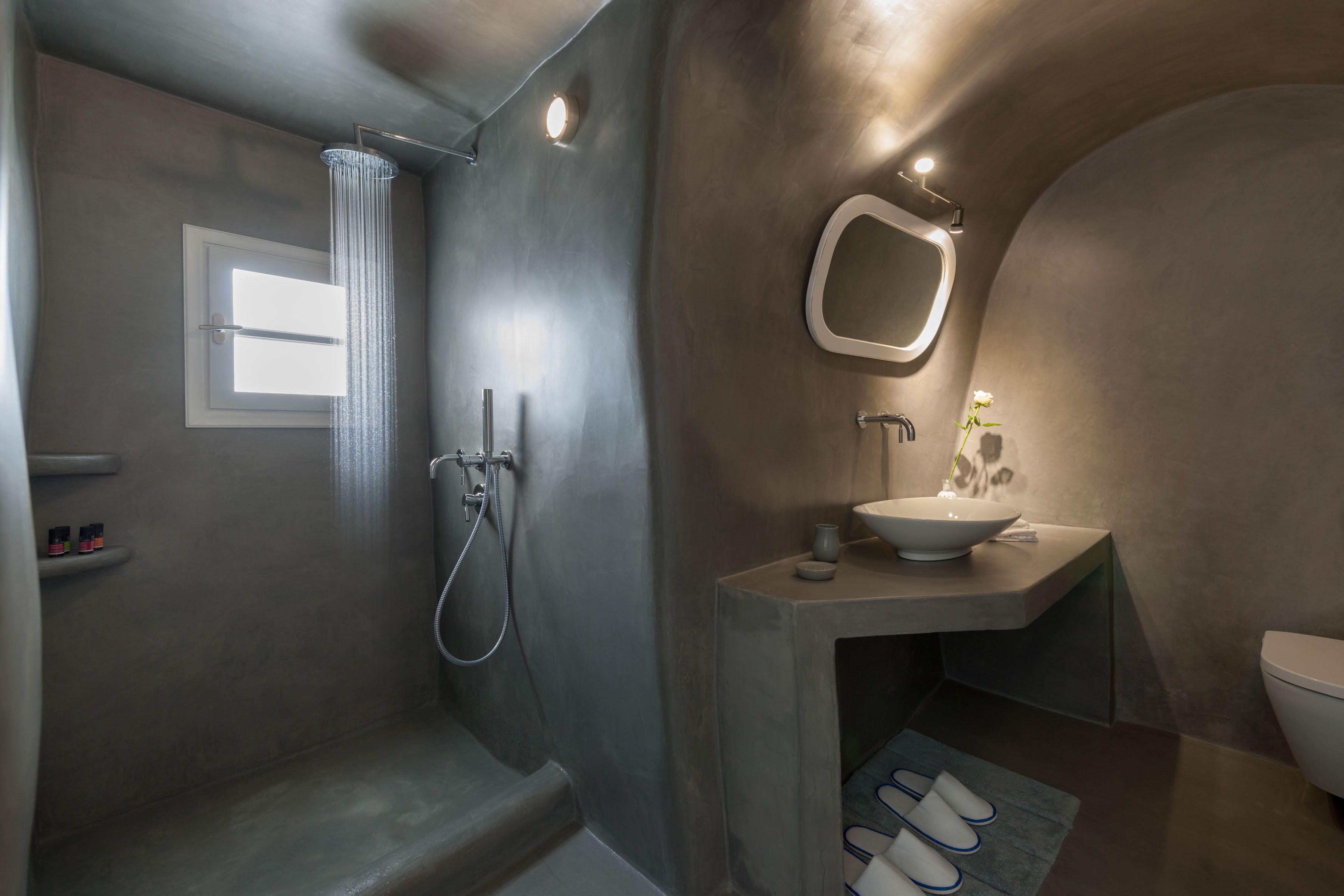 A modern bathroom with a shower, a sink, and a toilet.