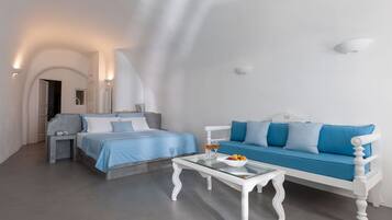 A modern hotel room with a bed, a sofa, and a glass coffee table.