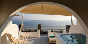 Relax on the balcony with a hot tub, lounge chair, and sea views.