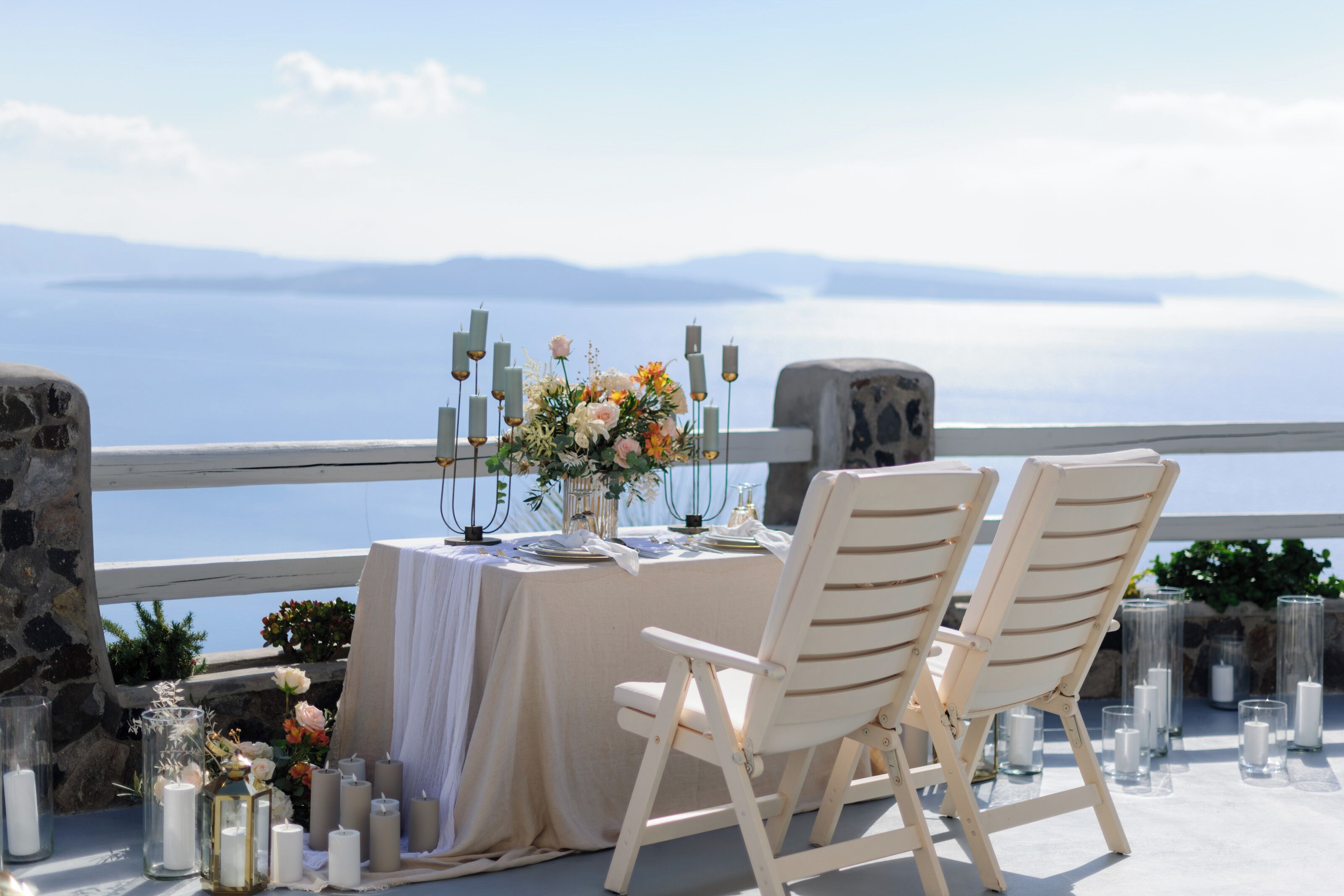 Ein Tisch mit Kerzen und Blumen, mit Blick auf eine schöne Landschaft.