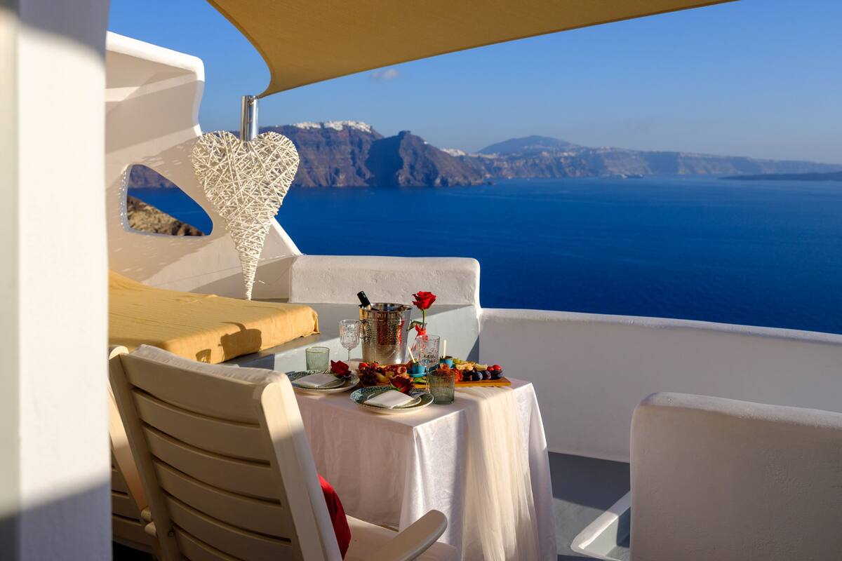 A table set for two with a view of the sea and cliffs.