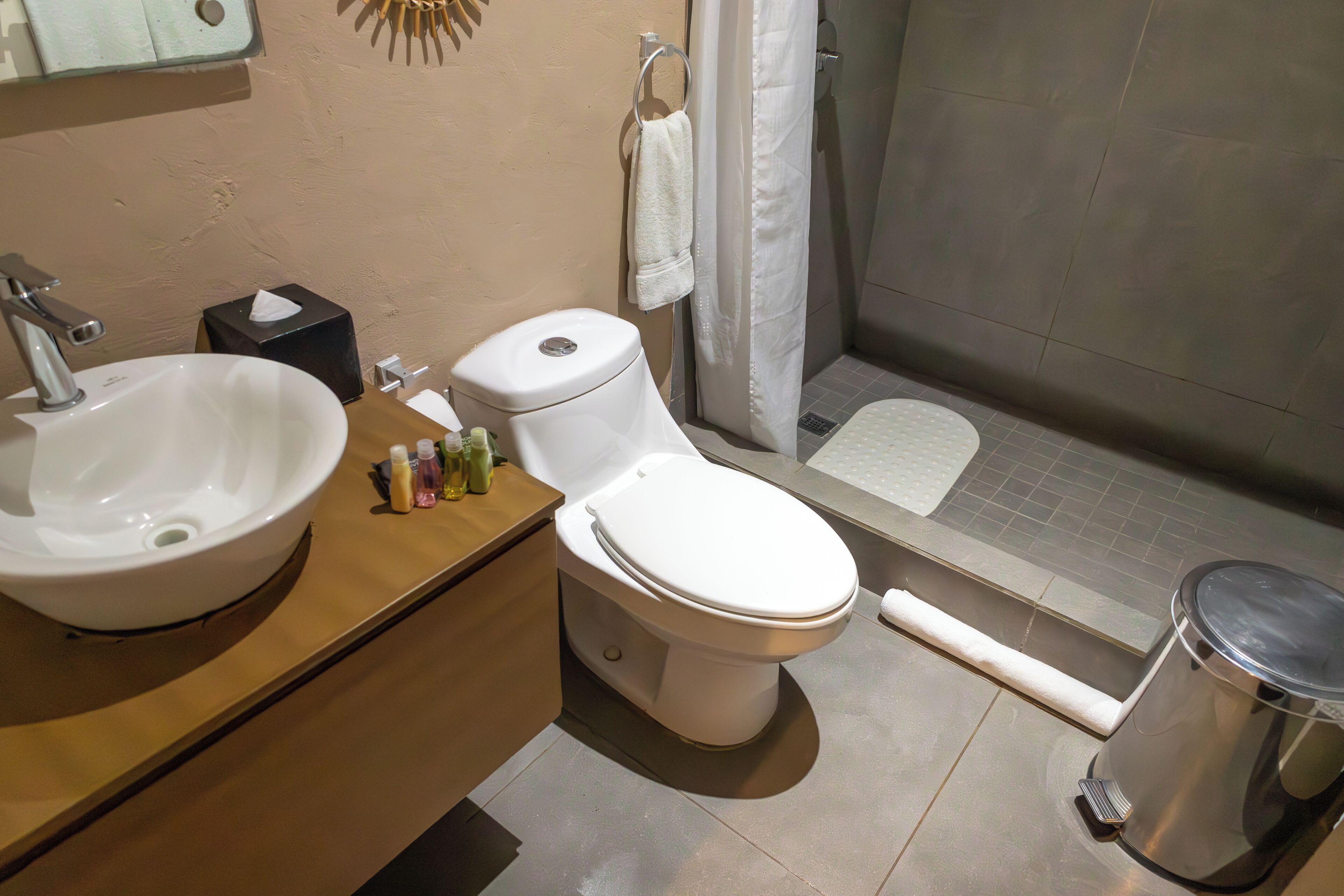 Une salle de bain comprenant un lavabo, des toilettes et un espace douche.