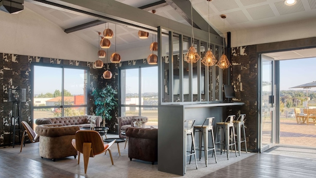 Een modern interieur met een bar, zitplaatsen en grote ramen met uitzicht.