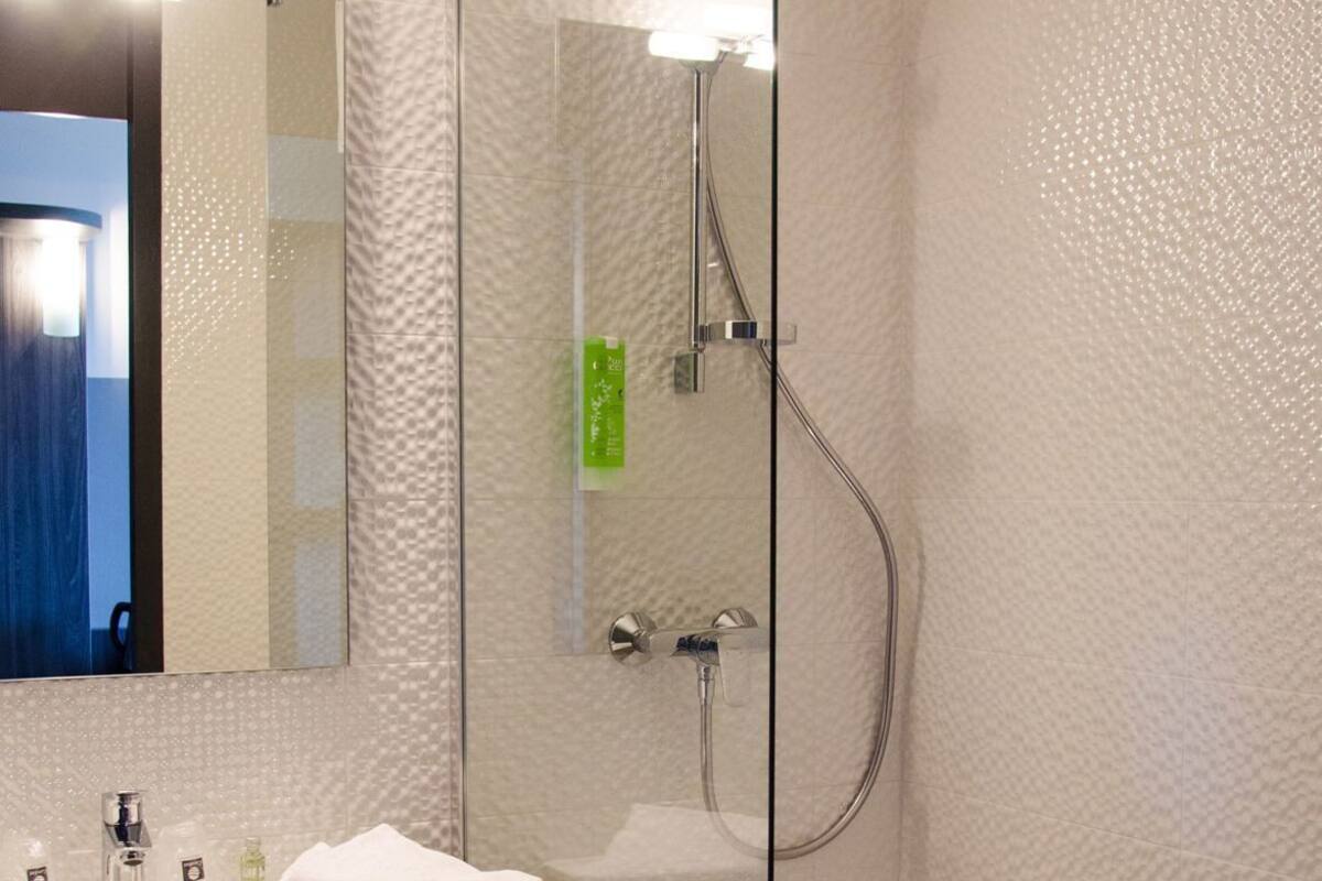 Ein modernes Badezimmer mit einer Duschkabine aus Glas, einem Waschbecken mit Spiegel und einer Holzausstattung.