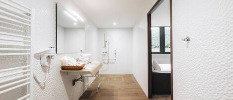 Un baño moderno con ducha, lavabo y espejo.