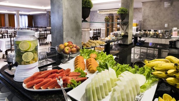 A buffet with various food items including sliced carrots, cucumbers, and bananas. - H Hotel (Balneário Camboriú)