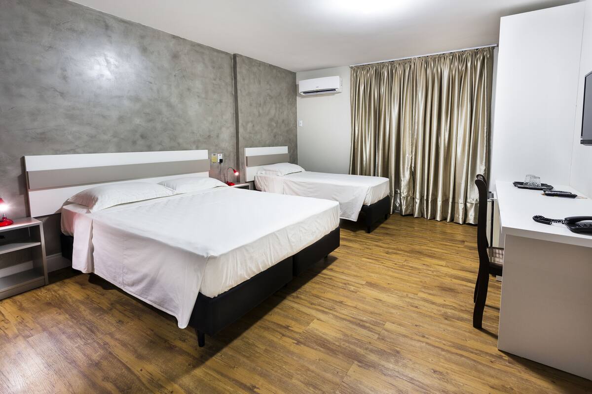Una habitación de hotel con dos camas, un escritorio y un televisor.
