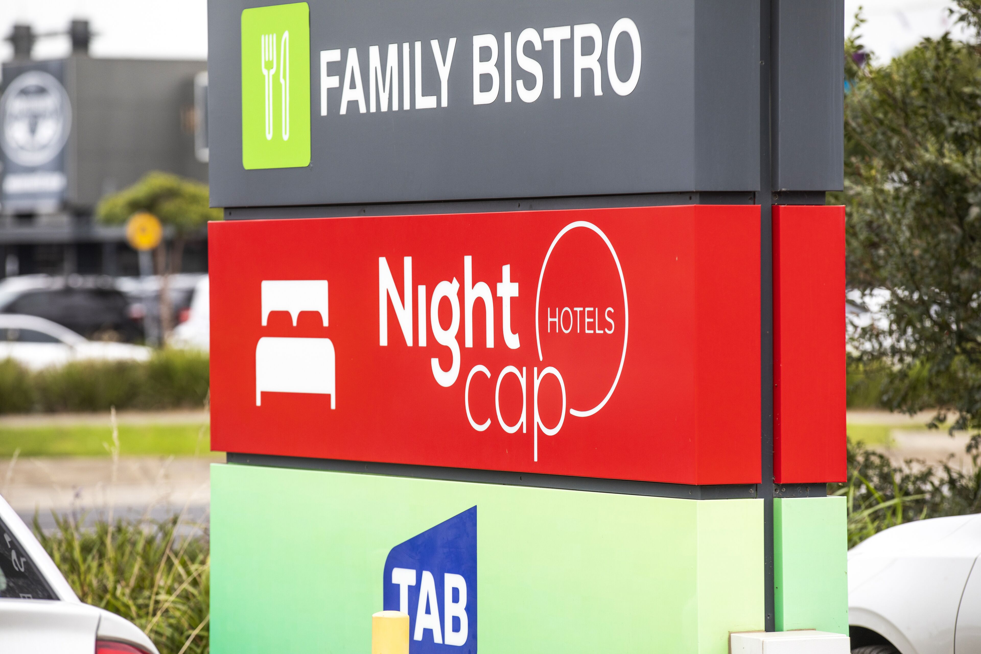 Señal que indica 'Family Bistro' y 'Nightcap Hotels', mostrando los servicios.