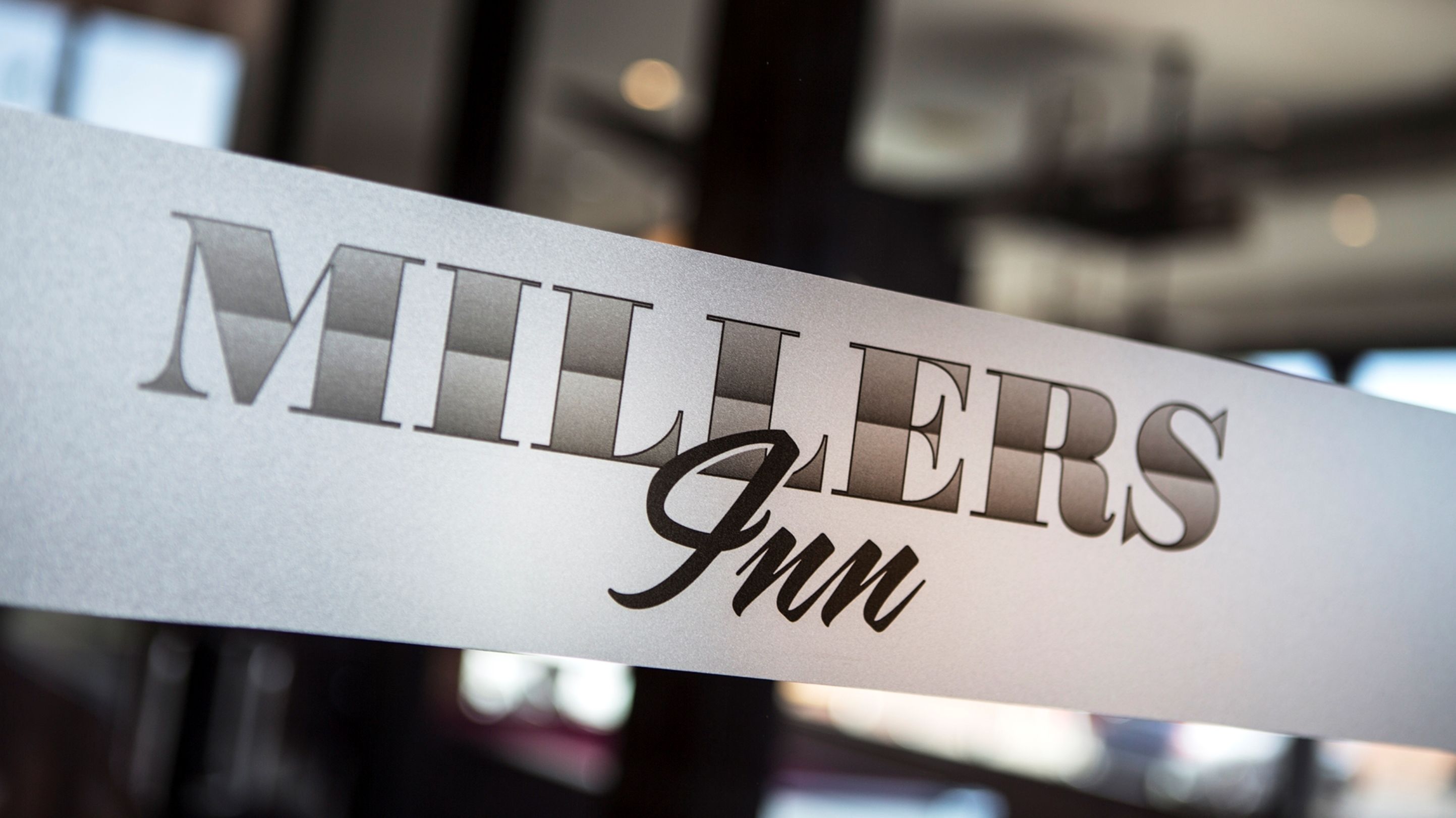 A sign with the name "MILLERS Inn" in a modern font.