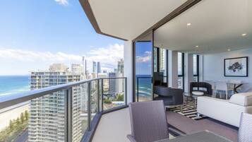 A balcony with a city view, a sofa, a dining table, and chairs.