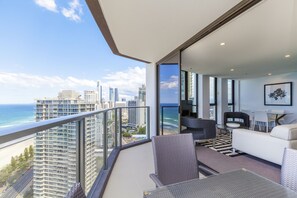A balcony with a city view, a sofa, a dining table, and chairs.