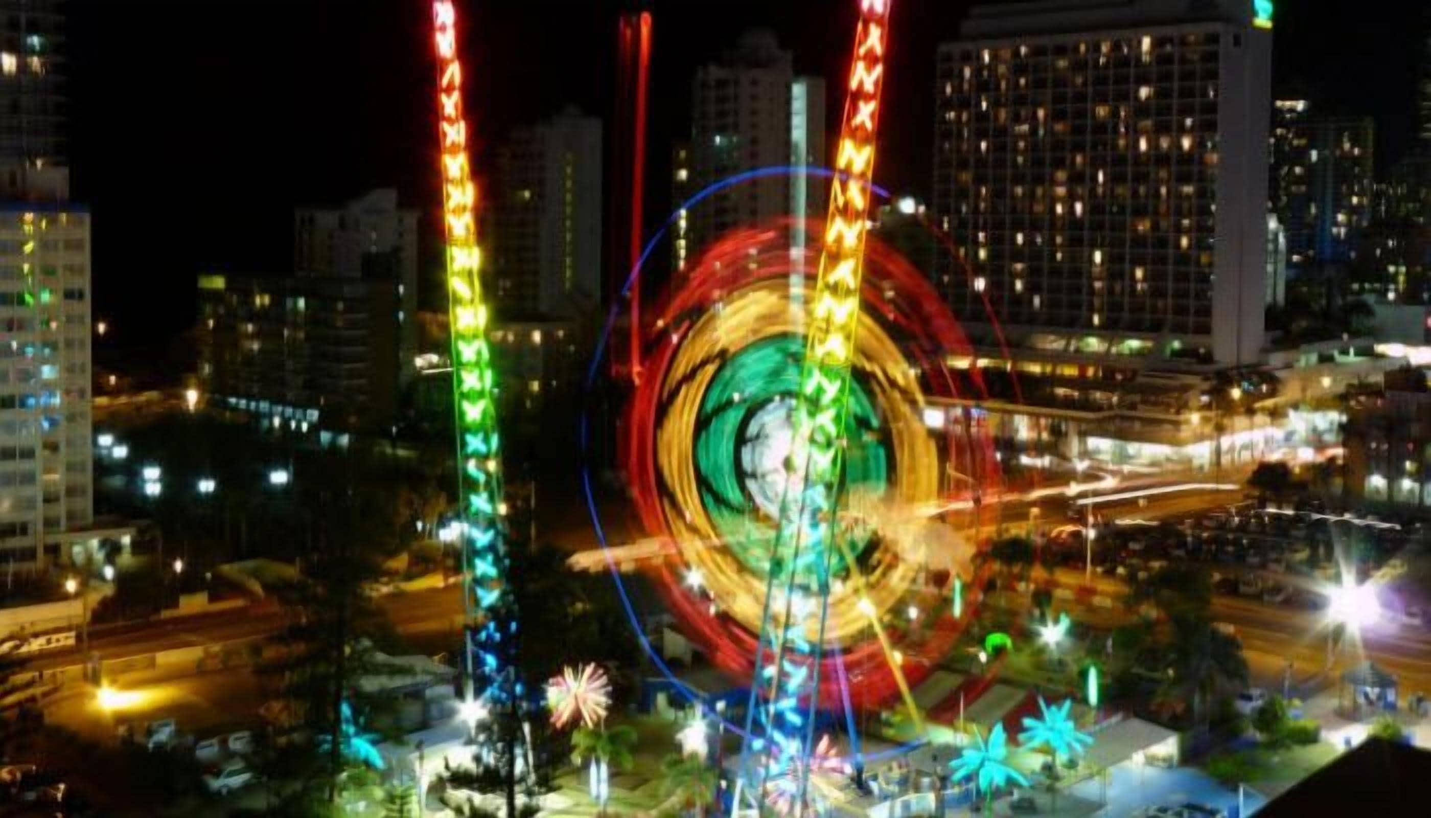 A cityscape at night with illuminated structures and a prominent circular light display.