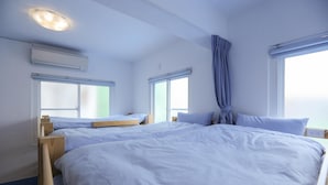 A bedroom with two beds, a window, an air conditioning unit, and a curtain. - Simple Travel - Hostel (Donggang)