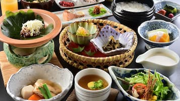 A variety of Japanese dishes including sushi, sashimi, and bowls of soup.