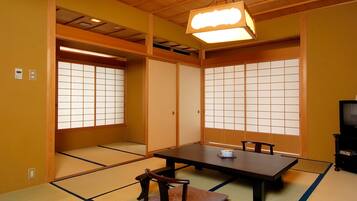 A traditional Japanese room with tatami flooring, a low table, and sliding doors.