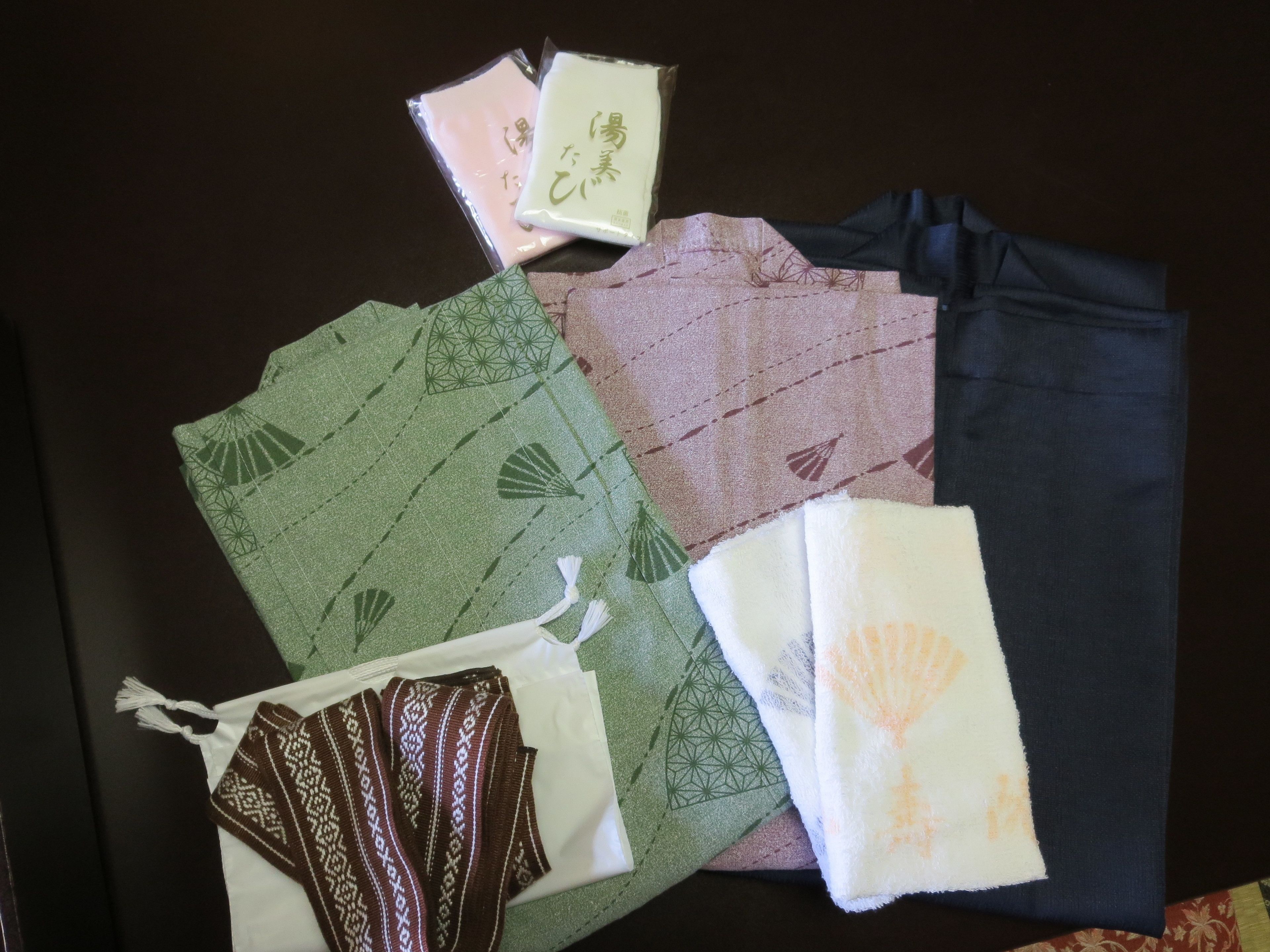 A variety of fabrics laid out on a dark surface.