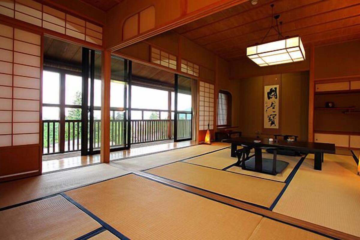 Een kamer met tatami matten, een lage tafel, schuifdeuren en een traditionele Japanse lantaarn.