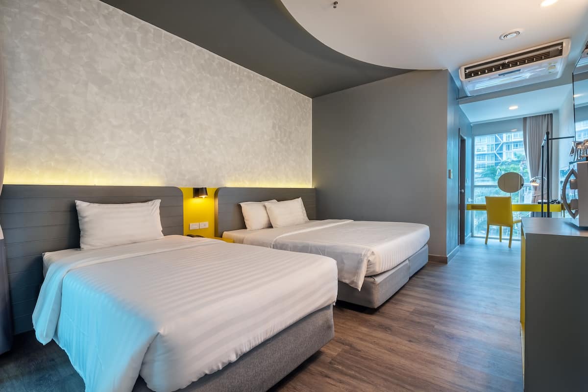 Una habitación de hotel con dos camas, un escritorio y una silla.