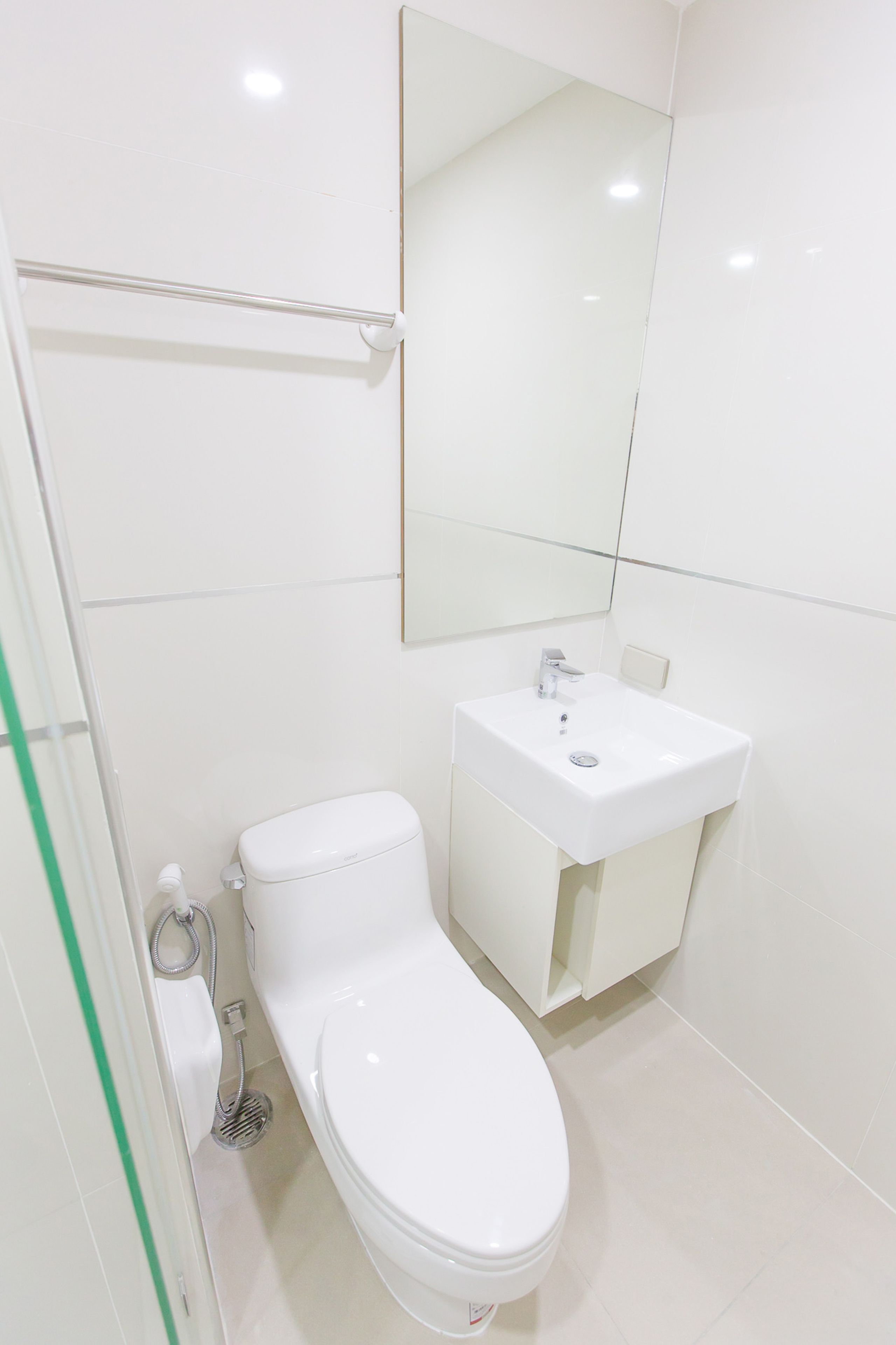 A modern bathroom with a white toilet, a sink, and a mirror.