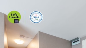 A hallway with a wooden floor, a built-in bench with storage, a small plant, and framed pictures. - Like Sukhumvit 22 (Bangkok)