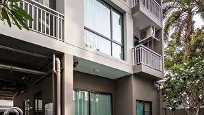 A swimming pool with clear blue water, surrounded by a modern building with balconies and large windows. - Like Sukhumvit 22 (Bangkok)