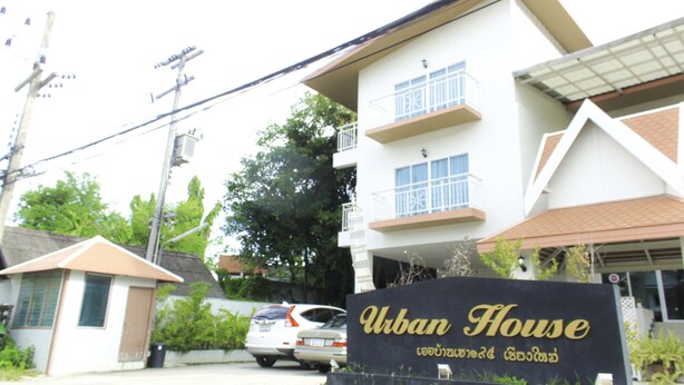 Schild für "Urban House" mit einem modernen Gebäude im Hintergrund.