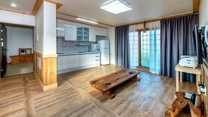 Una cocina moderna con armarios blancos, un banco de madera y una mesa de comedor.