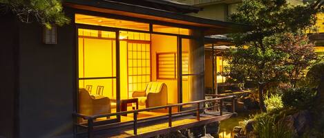 A traditional Japanese-style building with tatami mat flooring, a wooden deck, and a koi pond.