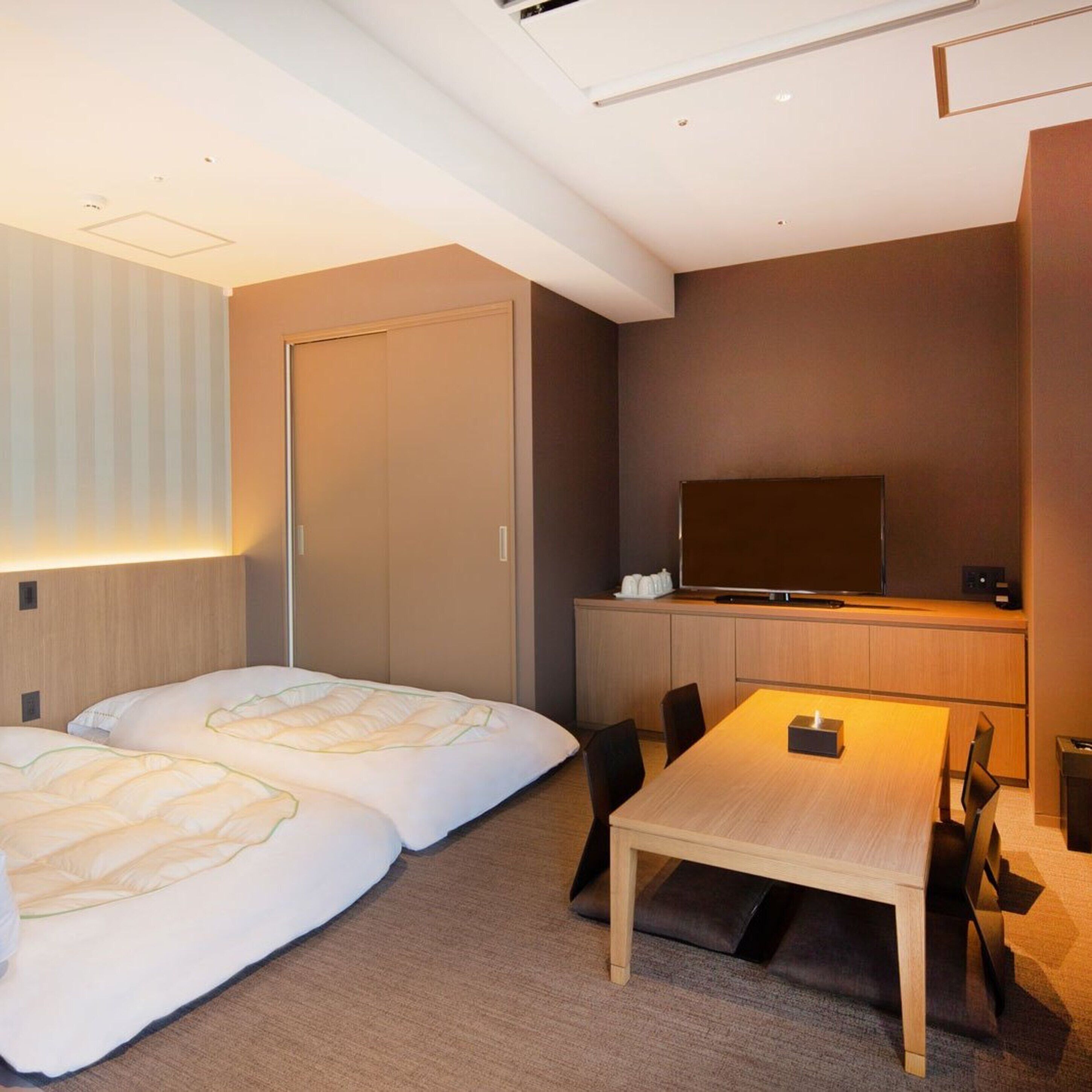 Una habitación de hotel moderna con una cama, un escritorio y una televisión.