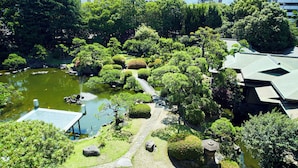Ein traditioneller japanischer Garten mit Teich für Koi-Karpfen, Steinlaternen und einer Steinbrücke.