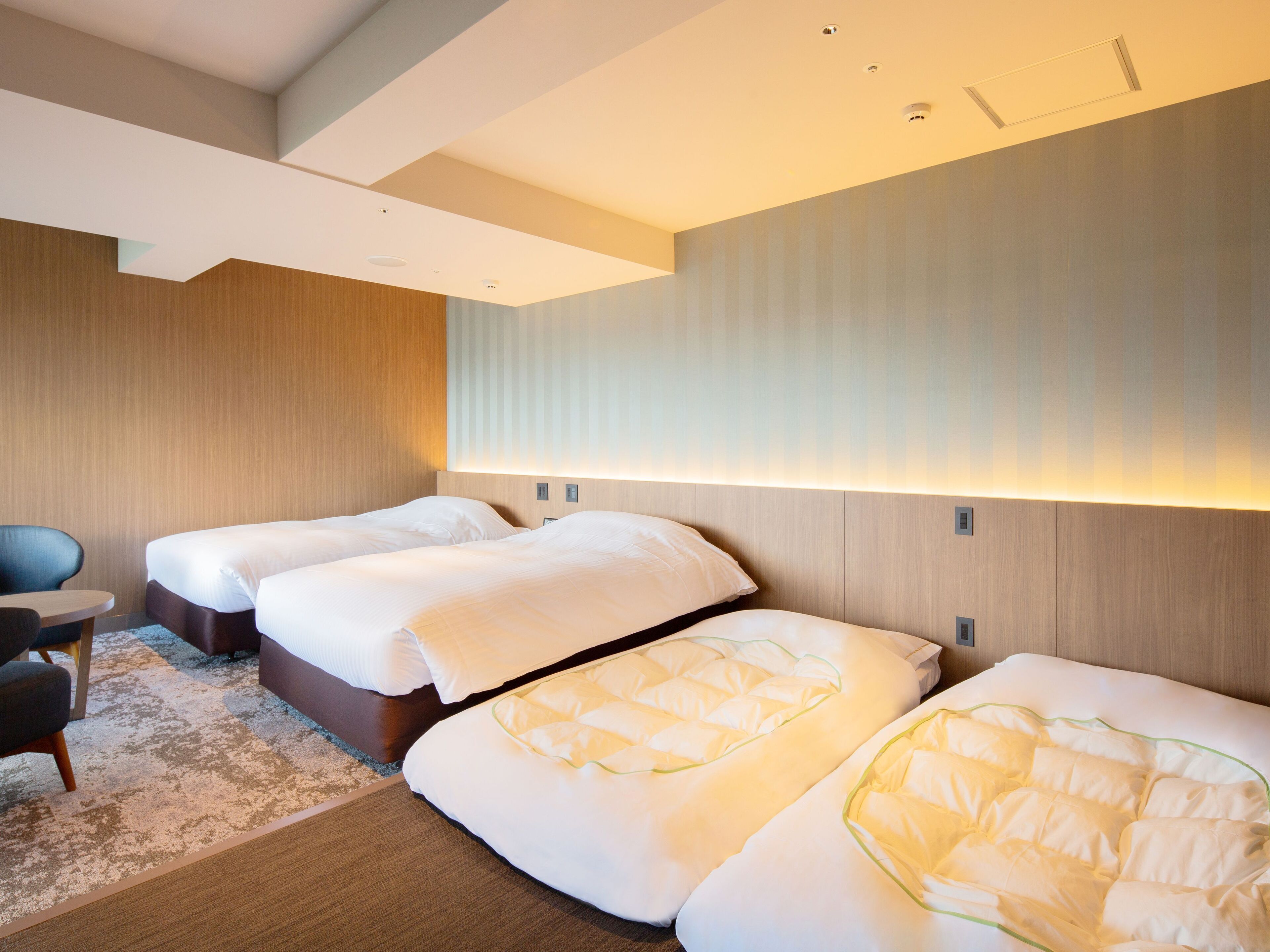 Habitación de hotel con dos camas, un escritorio y una silla.