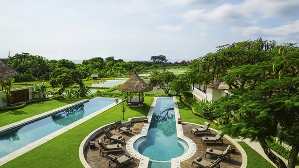 A resort with a central swimming pool, lounge areas, and lush greenery. - The Samata by LifestyleRetreats (Denpasar)