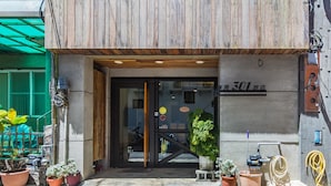 A hotel entrance with a wooden facade, a glass door, and a sign indicating room number 301. - Warehouse Inn (Hengchun)
