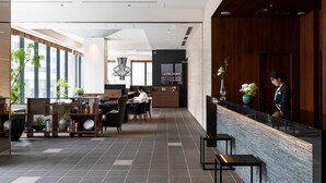 A modern hotel lobby with a reception desk, seating area, and a 'Safe The Lounge' sign. - Mitsui Garden Hotel Kyobashi Tokyo Station (Tokyo)