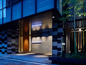 L'entrée d'un hôtel au design moderne, avec une enseigne bien visible indiquant « Mitsui Garden Hotel » et une façade bien éclairée.