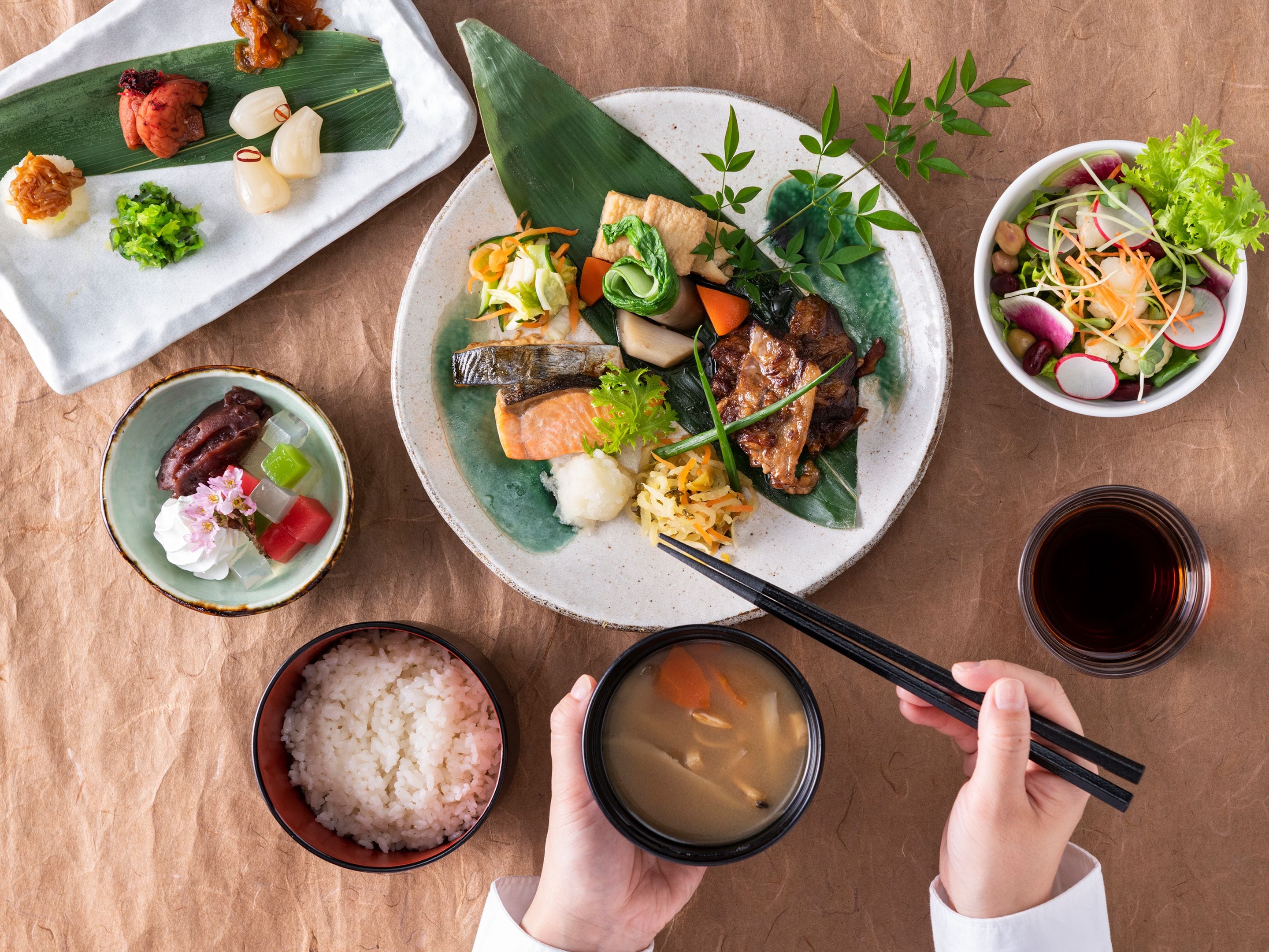 A variety of Japanese dishes including sushi, rice, and soup, served on ceramic plates.