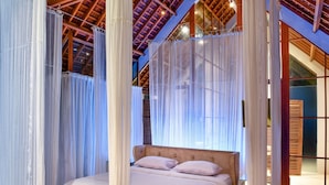 A bedroom with a canopy bed, wooden beams on the ceiling, and sheer curtains. - Villa Greenday (Cepaka)