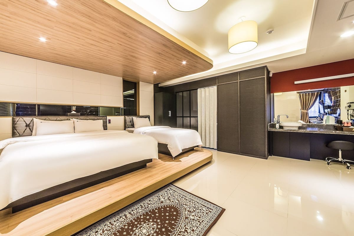Una habitación de hotel moderna con una cama grande, un escritorio y un baño.