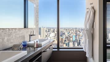 A modern bathroom with a large window, a sink, and a mirror.