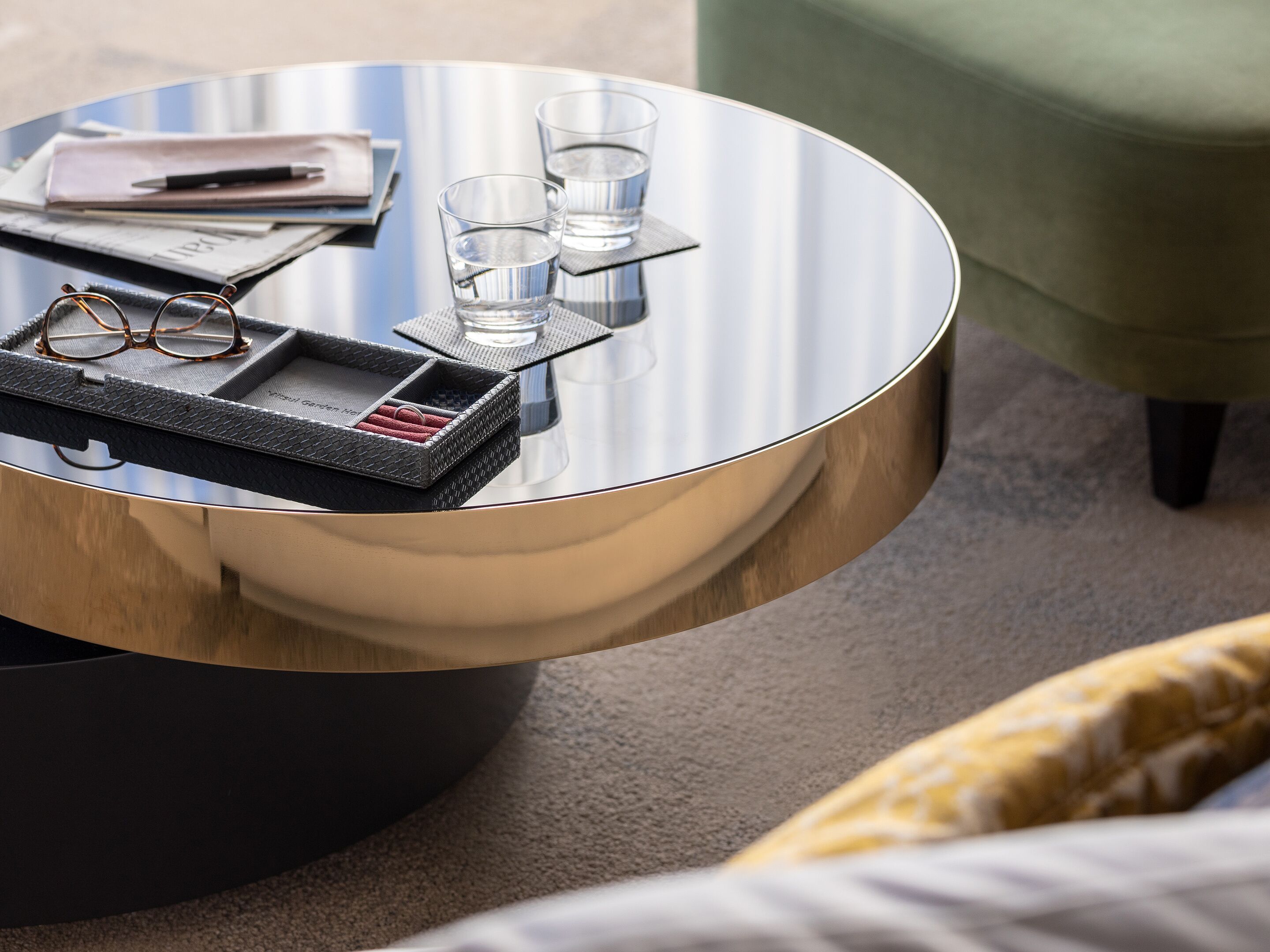 A round table with a tray, glasses, and two glasses of water.