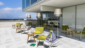 A rooftop terrace with outdoor seating, including chairs and tables, and a view of the cityscape. - OKKO Hotels Bayonne Centre (Bayonne)