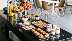 A breakfast buffet with croissants, fruits, jams, cheeses, and meats. - OKKO Hotels Bayonne Centre (Bayonne)
