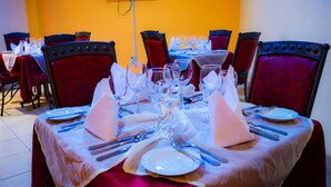 Une table à manger dressée pour un repas, avec plusieurs chaises disposées autour.
