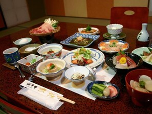 A dining table with various dishes and bowls, chopsticks, and a napkin with a logo.