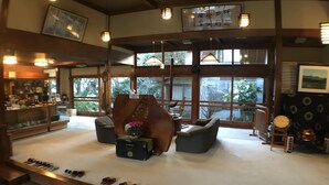 A spacious lobby with a shoe display, seating area, and large windows offering views of the outdoors.
