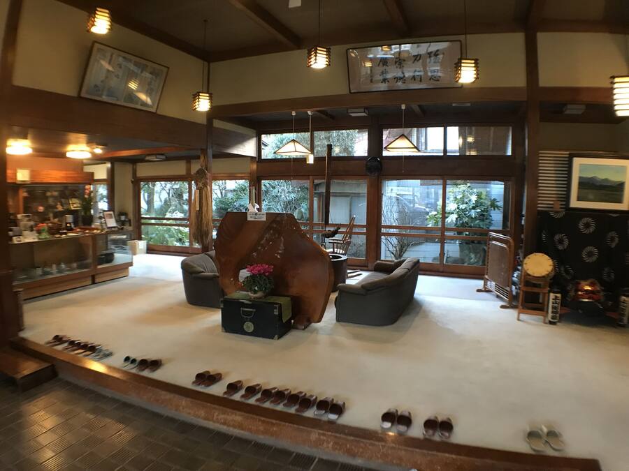 A spacious lobby with a shoe display, seating area, and large windows offering views of the outdoors.