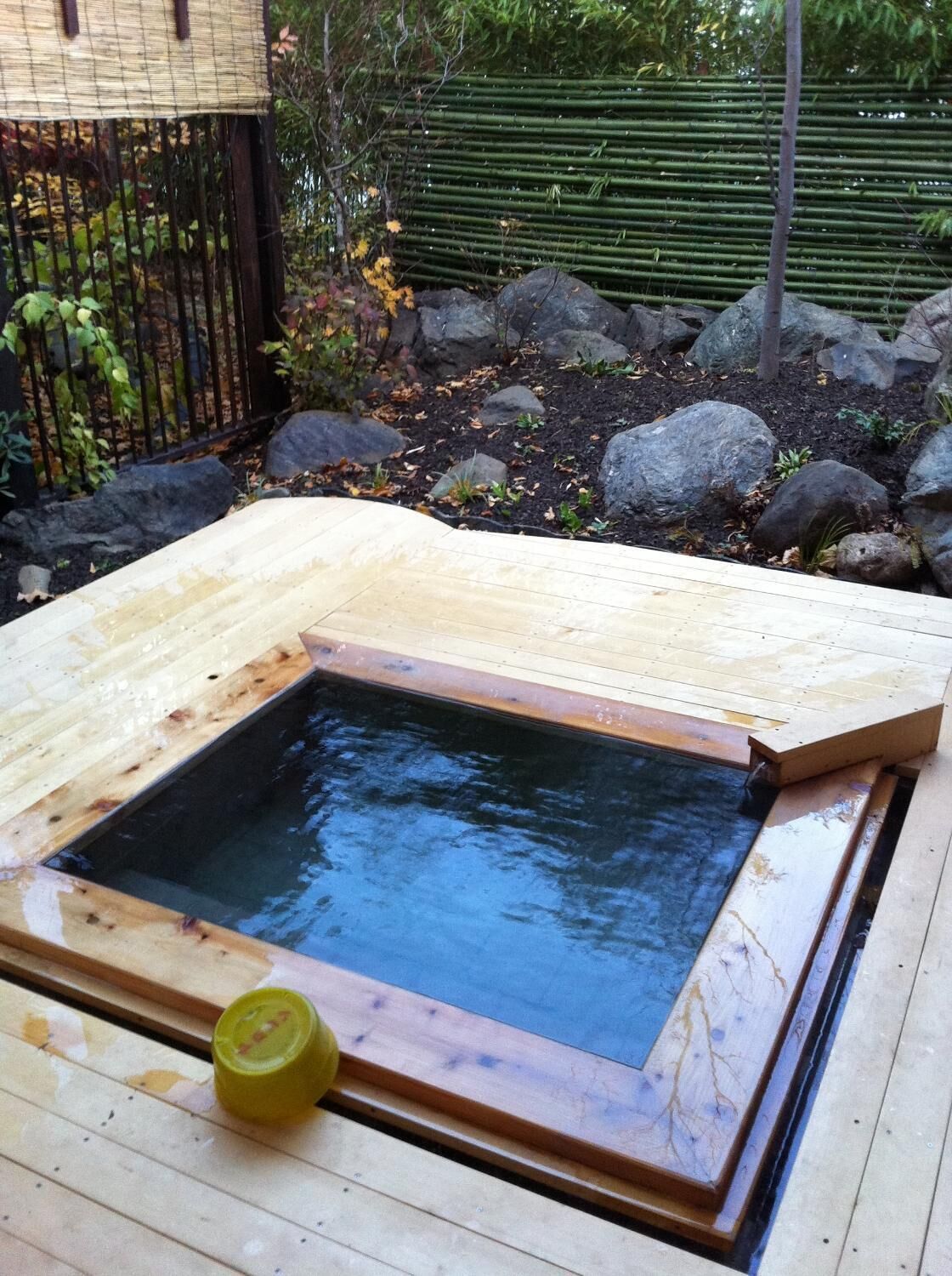 A hot spring with a wooden deck surrounding it.