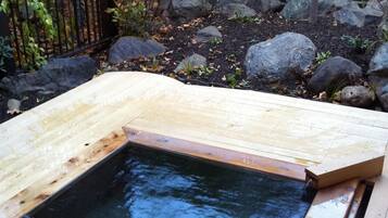 A hot spring with a wooden deck surrounding it.