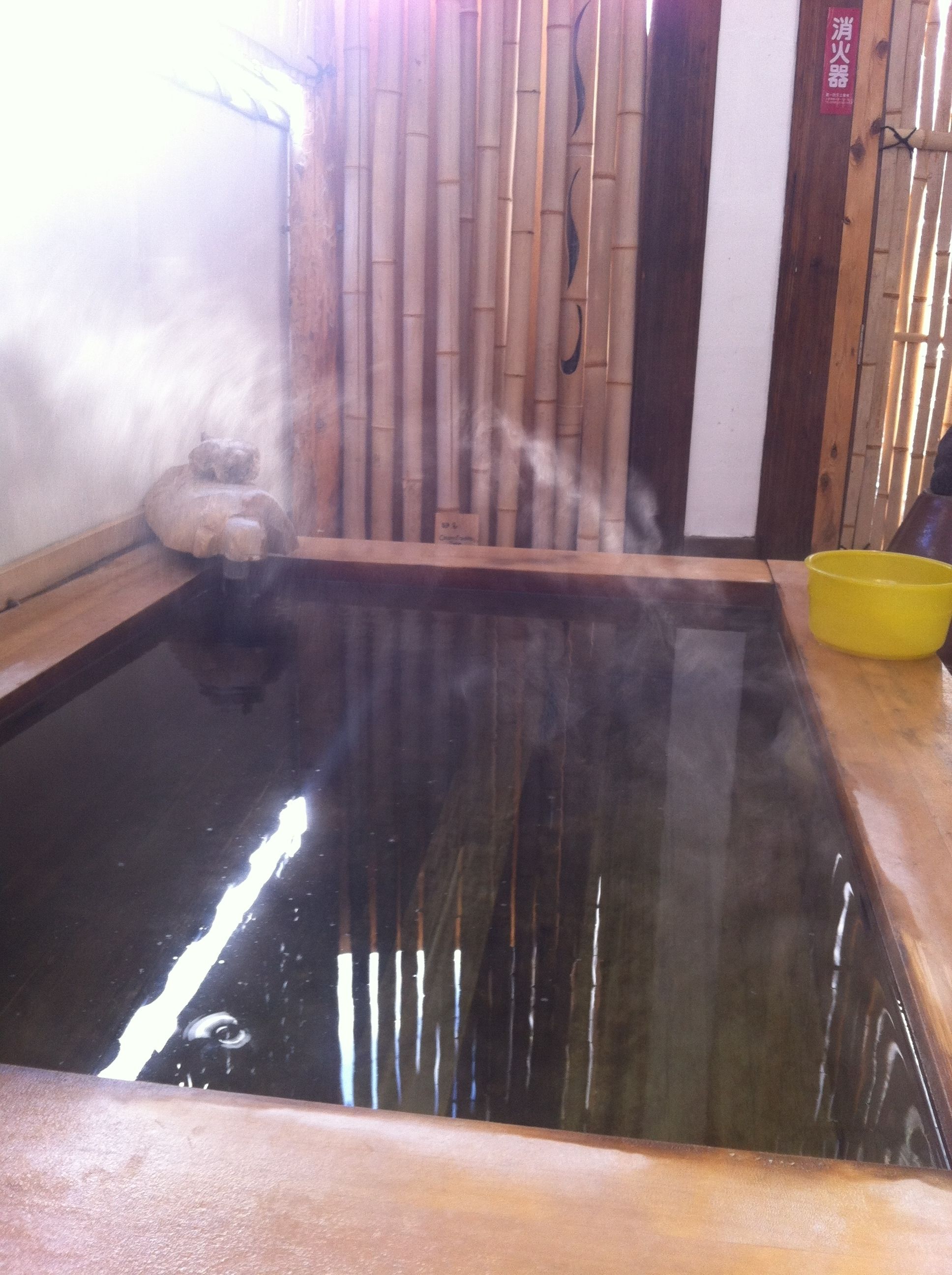 Un onsen japonais traditionnel, doté d’une plateforme en bois et d’un mur en bambou.