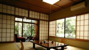 A traditional Japanese room with tatami flooring, a low table, and shoji screens.